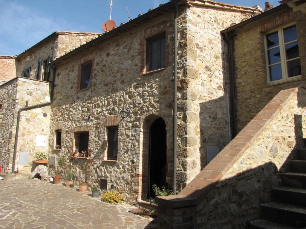 an old stone building with a staircase next to it at Al Piccolo Ulivo, a casa di Mimo&Sè in Castiglione dʼOrcia