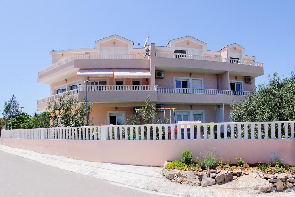 a large pink house with a white fence at Darijan Apartments in Marina