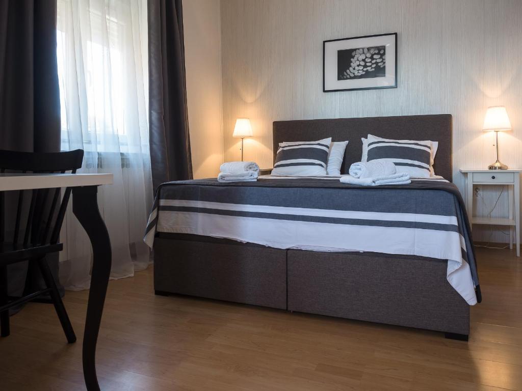 a bedroom with a large bed with two pillows at Apartments Nino 1 in Zadar