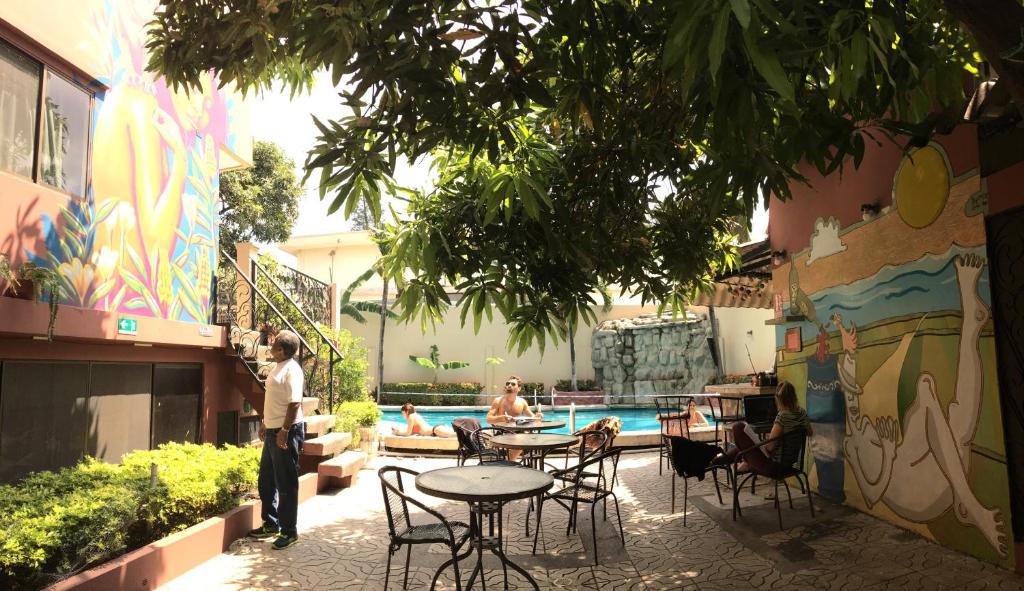 um grupo de pessoas sentadas à volta de uma mesa junto a uma piscina em Hostel Nucapacha em Guayaquil