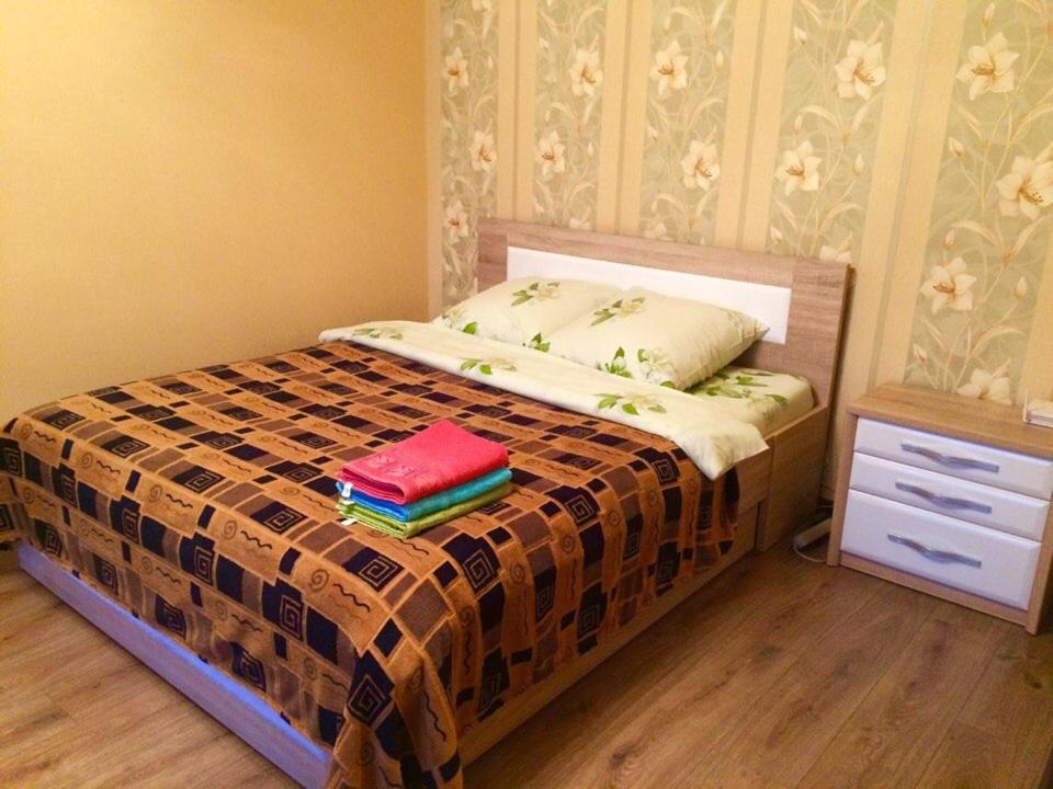 ein Schlafzimmer mit einem Bett mit zwei Büchern darauf in der Unterkunft Apartment Na Kamsamolskoy in Baranawitschy