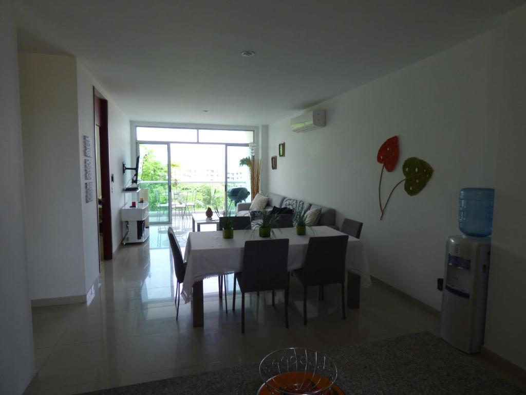 a dining room and living room with a table and chairs at Costa Azul Suites 401 in Santa Marta