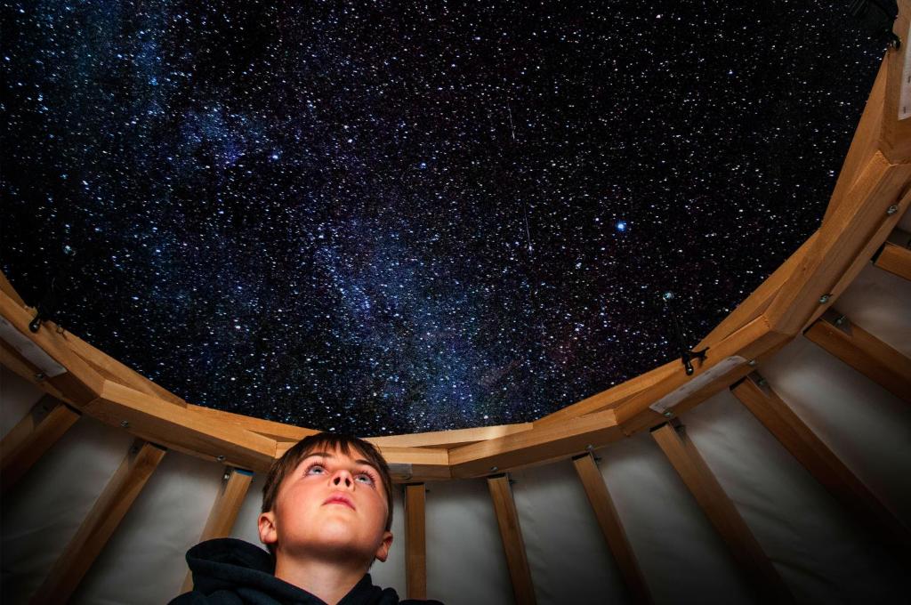 Człowiek patrzy w gwiazdy nieba w obiekcie Imago Village w mieście Saint-David-de-Falardeau