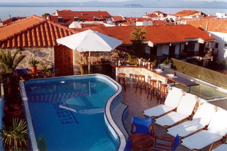 - une piscine avec des chaises et des parasols sur une maison dans l'établissement Hotel Flesvos, à Pefkohori