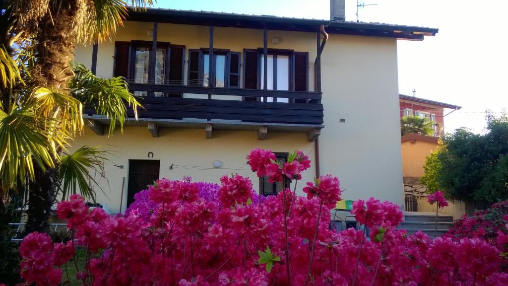 a house with pink flowers in front of it at Casa Bellavista - Lake Maggiore view and garden in Baveno