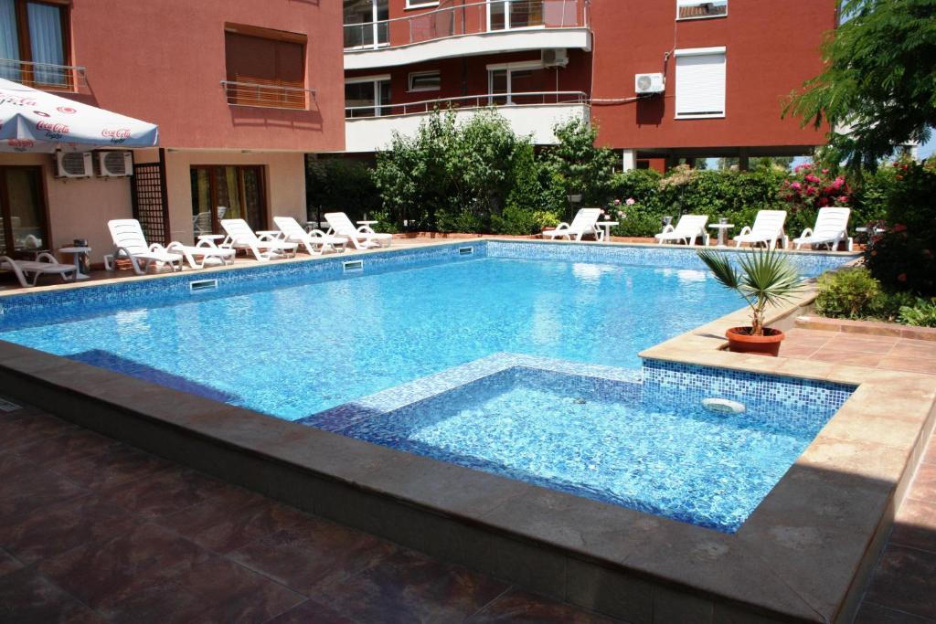 a large swimming pool with chairs and a building at Apart-Hotel Onegin & Thermal Zone in Sozopol