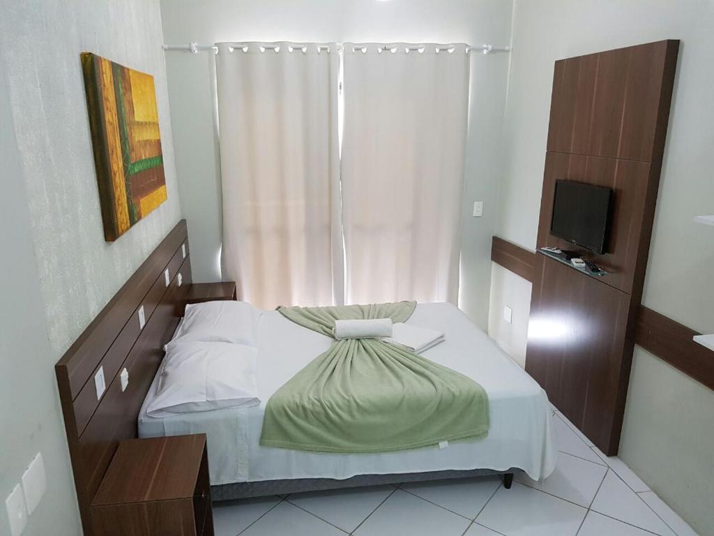 Pousada Ilhas Gregas في فلوريانوبوليس: غرفة نوم فيها سرير وتلفزيون