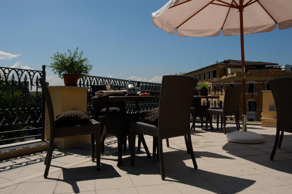 a patio area with chairs, tables and umbrellas at Hotel Latinum in Rome