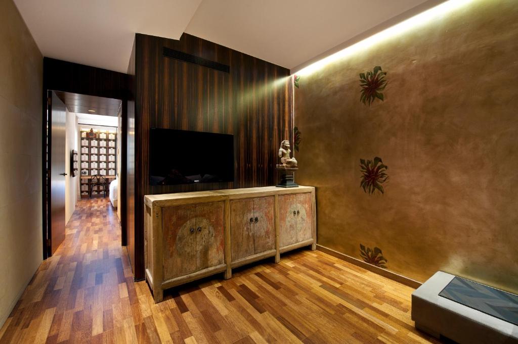 a living room with a television on a wall at Claris Hotel & Spa GL, a Small Luxury Hotel of the World in Barcelona