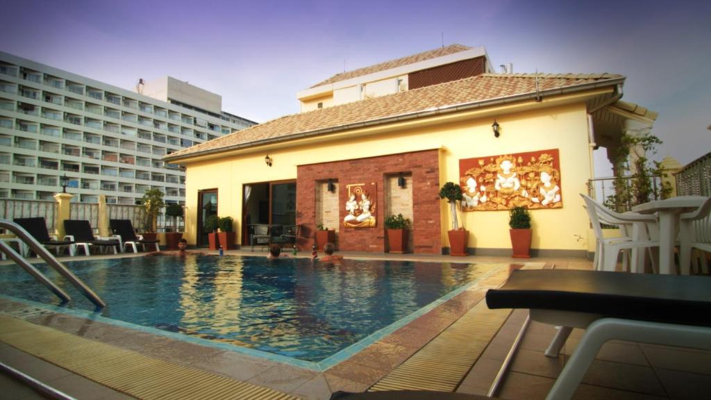 a hotel swimming pool with chairs and a building at Royal Park Apartments in Jomtien Beach