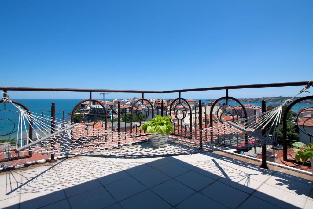 a balcony with a hammock and a view of the city at Family Hotel Verona in Sozopol