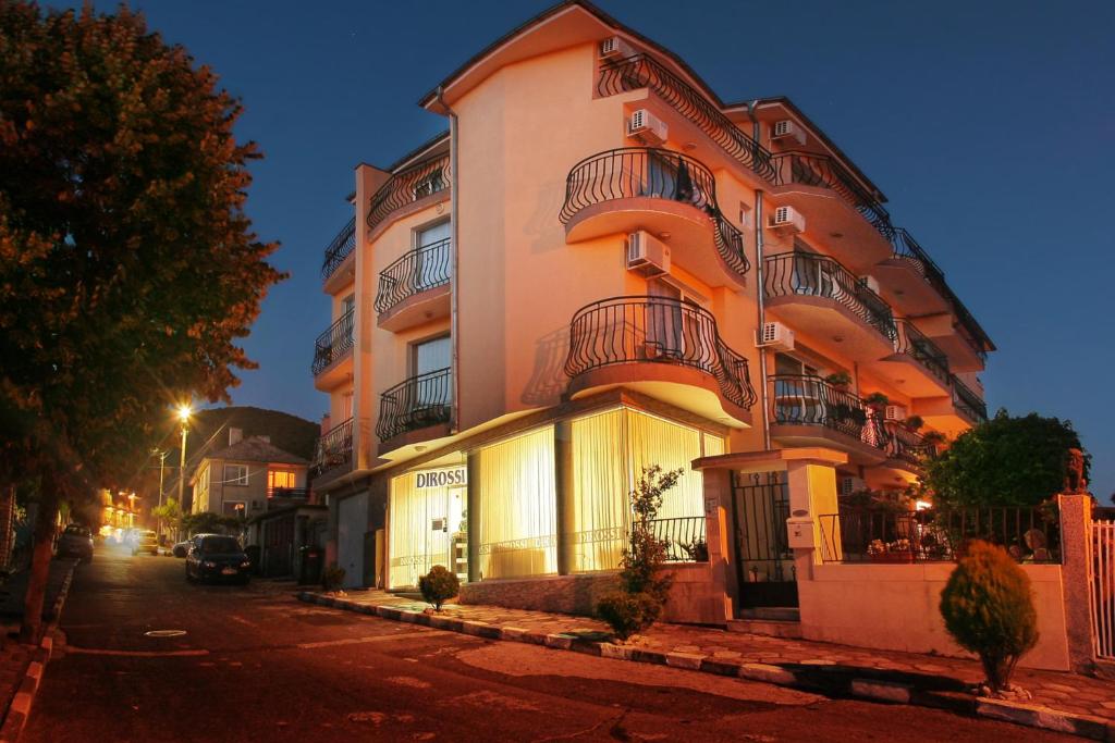 a tall building on a city street at night at ,,Дироси'' in Sveti Vlas