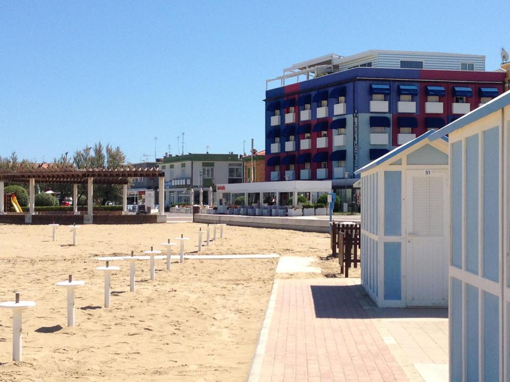 a sandy beach with a building and a building at Astoria in Fano