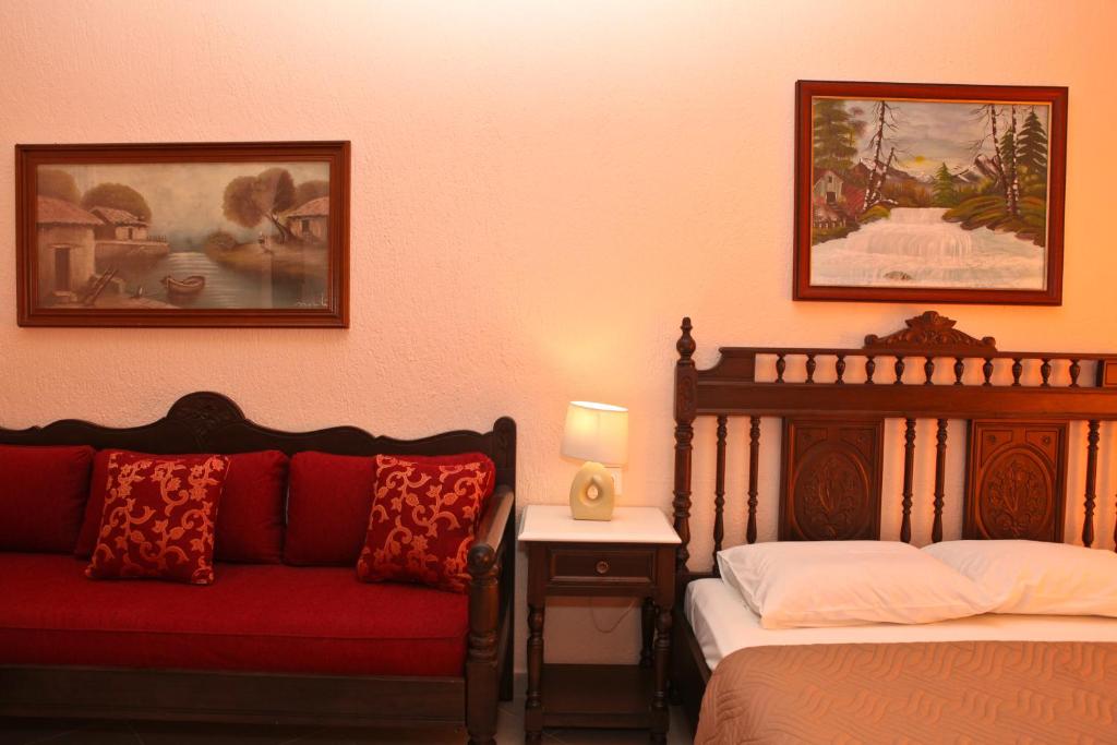 a bedroom with two beds and a red couch at Maria Studios in Neo Klima