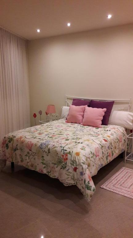 a bedroom with a large bed with pink and purple pillows at El Lagar De ElCiego in Elciego