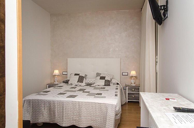 a bedroom with a large bed and two night stands at Hostal Don Rodrigo in Zamora