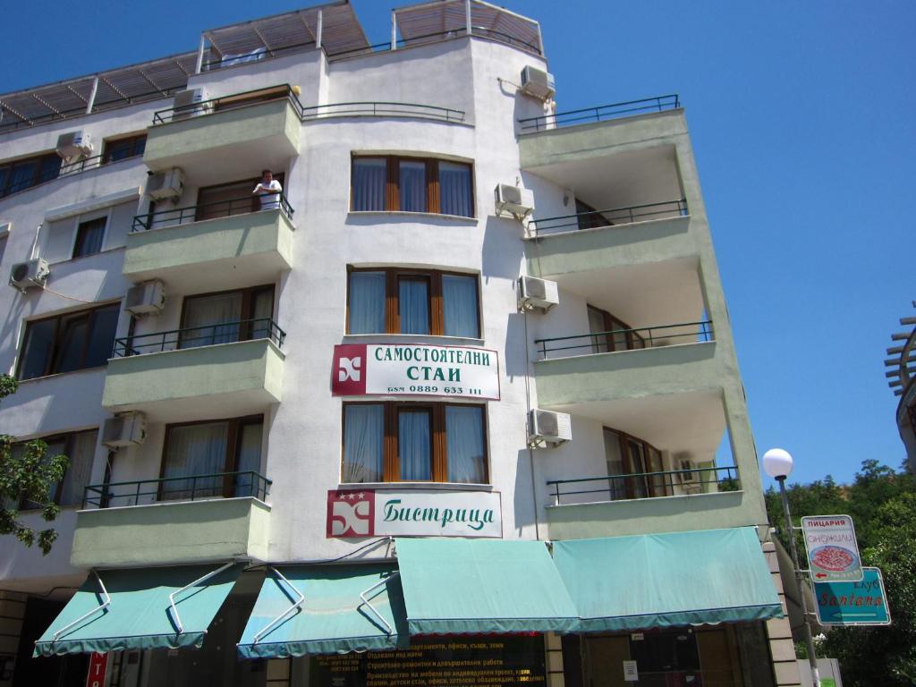 un edificio blanco con un cartel. en Family Hotel Bistritsa en Sandanski