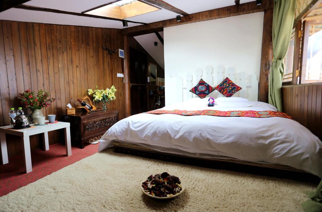a bedroom with a large bed and a bowl of fruit on the floor at Shangri-La mid - mountain homestay in Shangri-La