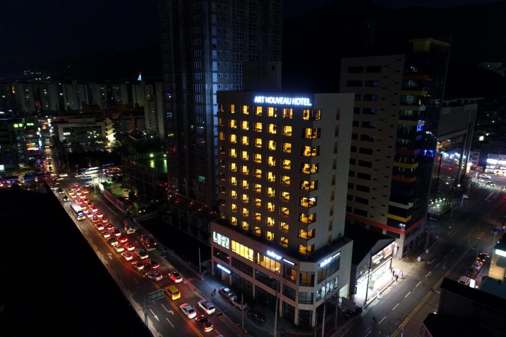 ein beleuchtetes Gebäude in einer Stadt in der Nacht in der Unterkunft Geoje Artnouveau Suite Hotel in Geoje