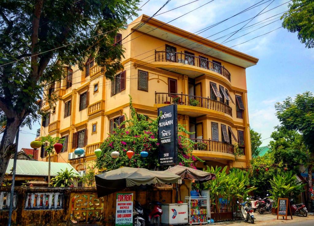 a yellow building with flowers in front of it at DK's Backpacker Hotel in Hoi An