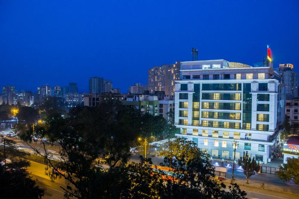 un edificio con una bandera encima de él por la noche en The Byke Suraj Plaza Pure Veg, Thane en Thane