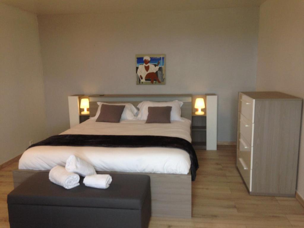 a bedroom with a large bed with two white towels at Ferme auberge du col de la vaccia in Olivese