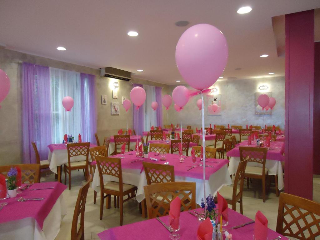 una sala banchetti con palloncini rosa, tavoli e sedie di Hotel Mont Blanc a Bellaria-Igea Marina