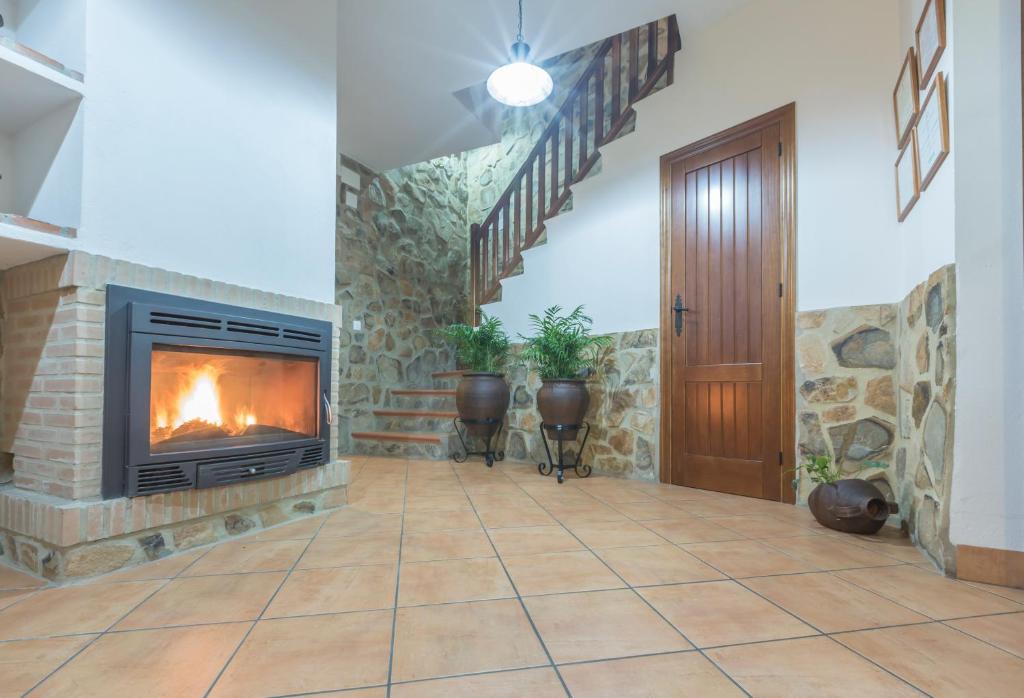 a living room with a fireplace and a staircase at Casa Rural La Fuente in Segura de León