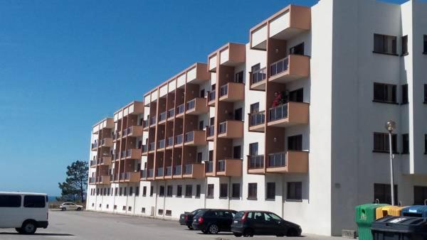 ein großes Apartmenthaus mit Autos auf einem Parkplatz in der Unterkunft Apartamento T3 Amorosa in Viana do Castelo