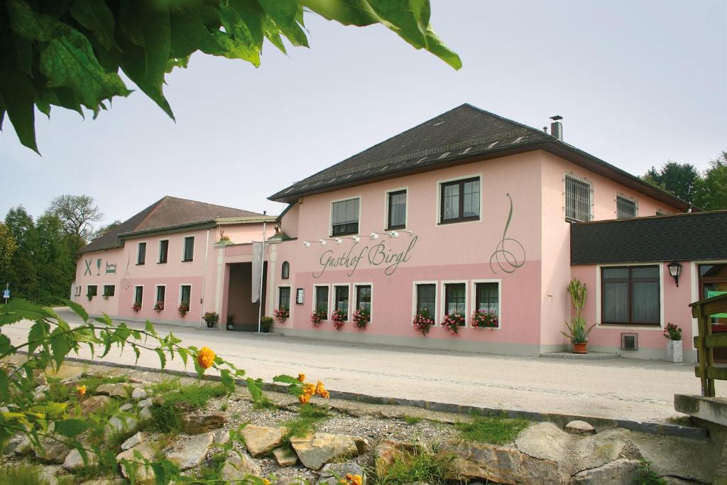 un edificio rosa con flores delante en Gasthof Birgl en Inning