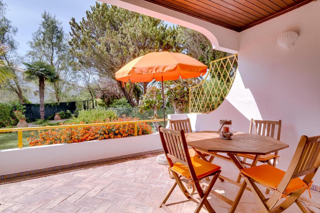 a patio with a table and chairs and an umbrella at Apartamento Victoria in Vilamoura