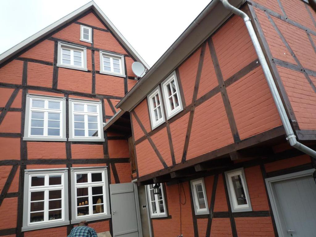 a man is standing in front of a house at Cavallino Herberge in Plau am See