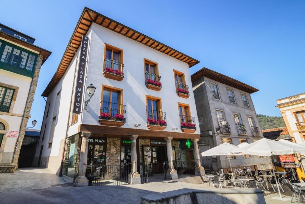 a building with tables and chairs in front of it at Plaza Mayor in Villafranca del Bierzo