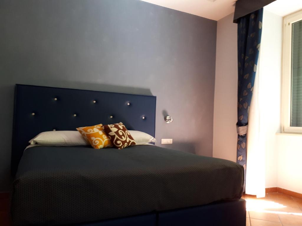 a bedroom with a bed with a blue headboard at Clodio Rooms in Rome