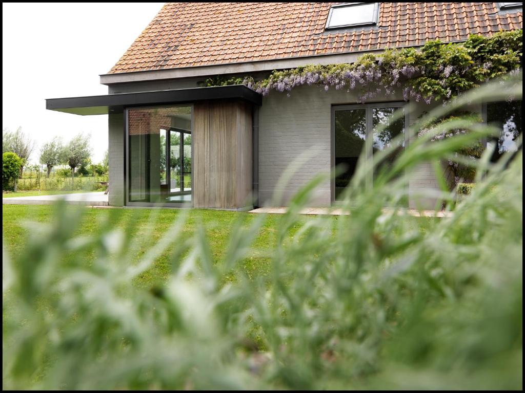 une maison avec une fenêtre et une pelouse dans l'établissement Rooseboom22, à Aartrijke