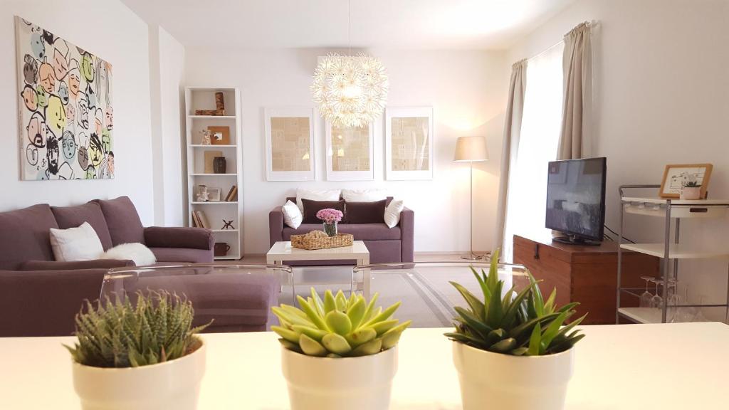 ein Wohnzimmer mit einem Sofa und einem Tisch mit Topfpflanzen in der Unterkunft Skenza's loft 68m2 in Split