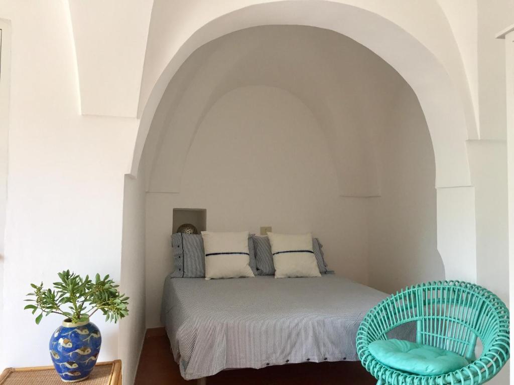 - une chambre avec un lit et une chaise bleue dans l'établissement Studio Alli, à Pantelleria