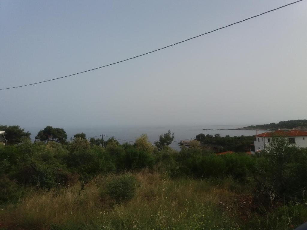 a view of the ocean from a hill at Ikosrooms in Votsi