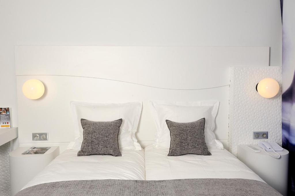 Кровать или кровати в номере Kyriad Prestige Perpignan Centre Gare