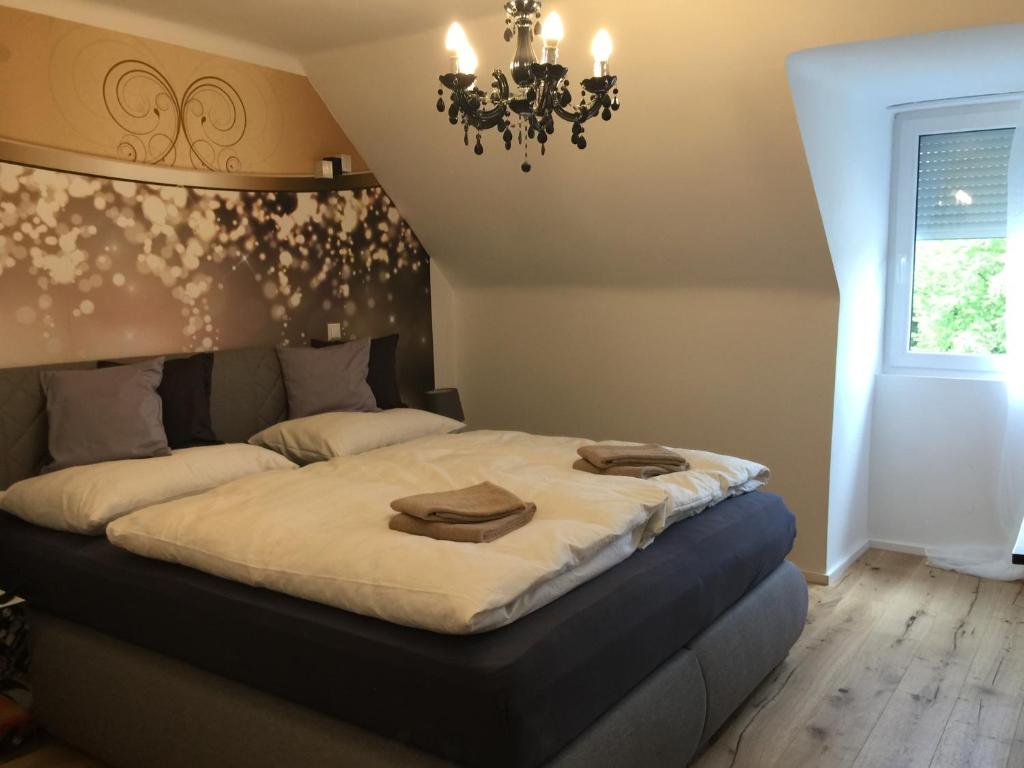 a bedroom with a large bed with a chandelier at Enjoyit Rooms in Velden am Wörthersee