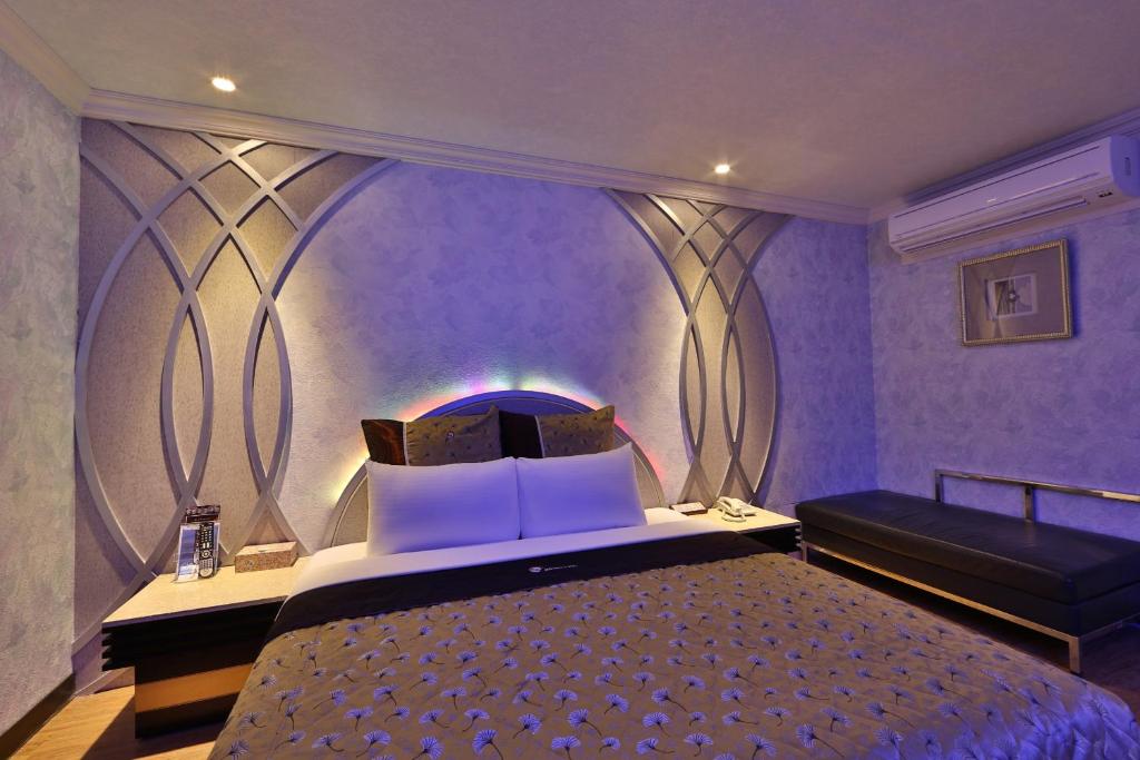 a purple bedroom with a bed and a couch at Full Moon Motel in Shulin