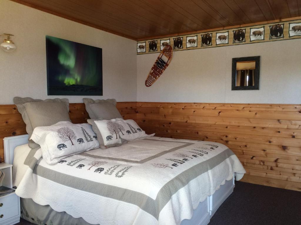 Caribou Lodge Alaska في تالكيتنا: غرفة نوم بسرير كبير في غرفة