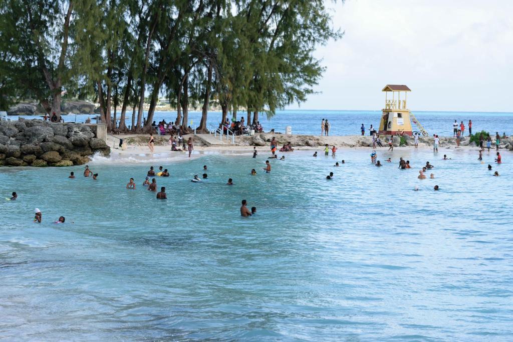a group of people swimming in the water at a beach at Glynver Apartments in Christ Church
