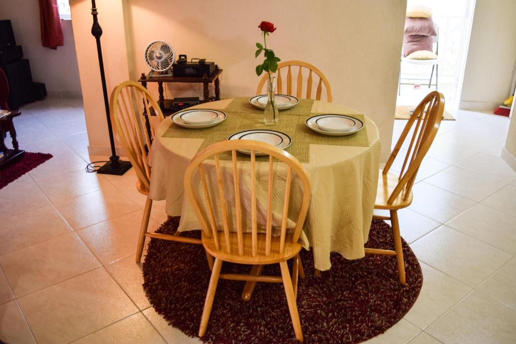 a dining room table with chairs and a vase of flowers on it at Glynver Apartments in Christ Church
