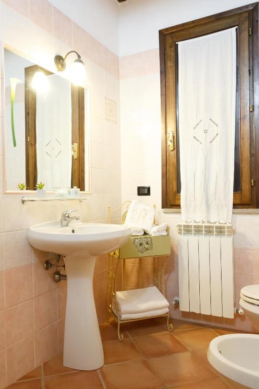 biała łazienka z umywalką i toaletą w obiekcie Agriturismo Il Rustico w mieście Marina di Grosseto