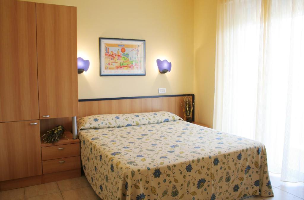 Schlafzimmer mit einem Bett und einem Fenster in der Unterkunft Residence Blumarine in Giulianova