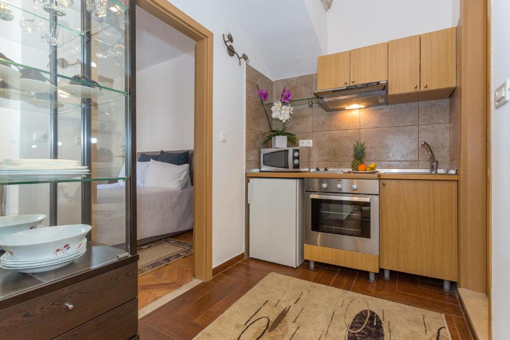 a small kitchen with a sink and a microwave at Apartment and Rooms Stay in Dubrovnik