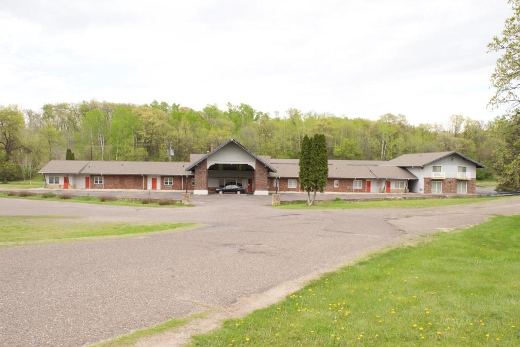 a large house with a driveway in front of it at AmeriVu Inn & Suites - St Croix Falls in Saint Croix Falls