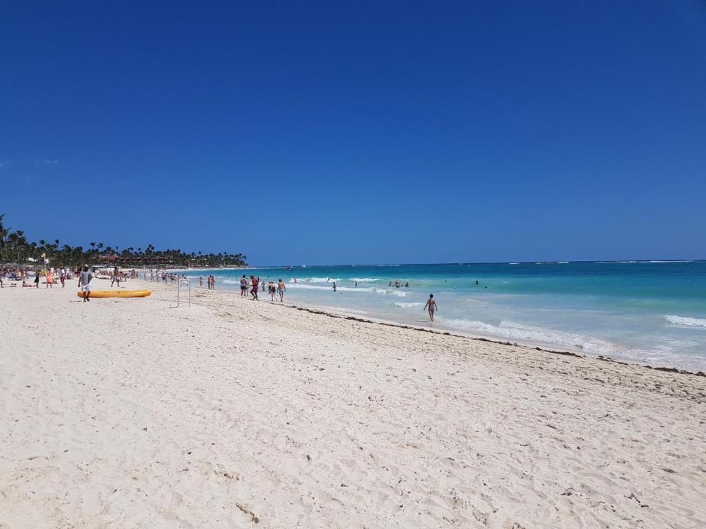 um grupo de pessoas em uma praia com o oceano em Punta Del Este Excepcional Ubicación em Punta del Este