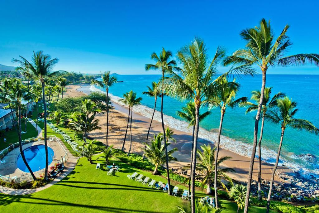 uma vista aérea de um resort com palmeiras e o oceano em The Hale Pau Hana em Kihei